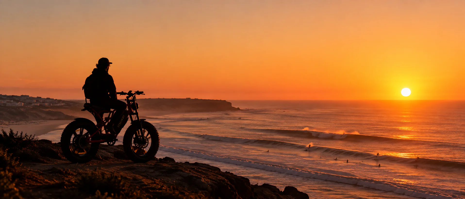 E-bike rider overlooking the Atlantic surf at sunset